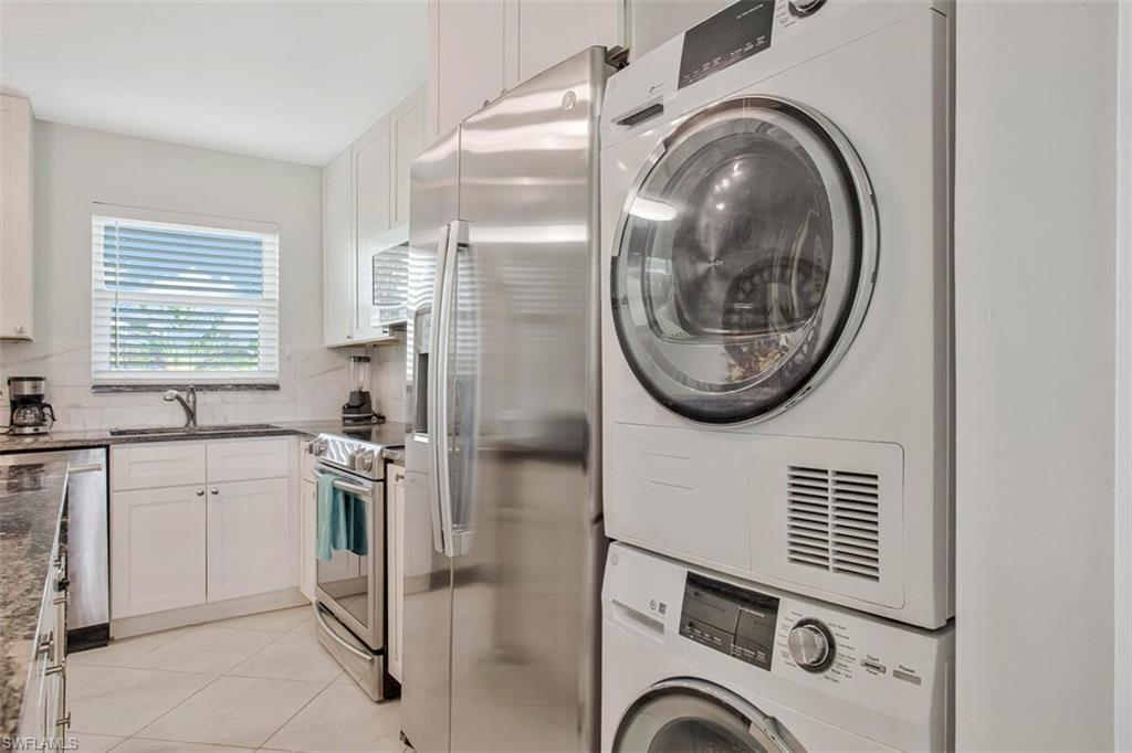 4380 27th Court Southwest, Unit 1 Naples, FL 34116 - Photo 13 of 34 Laundry room featuring light tile patterned floors and stacked washer / dryer