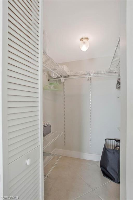 4380 27th Court Southwest, Unit 1 Naples, FL 34116 - Photo 17 of 34 Walk in closet with light tile patterned floors