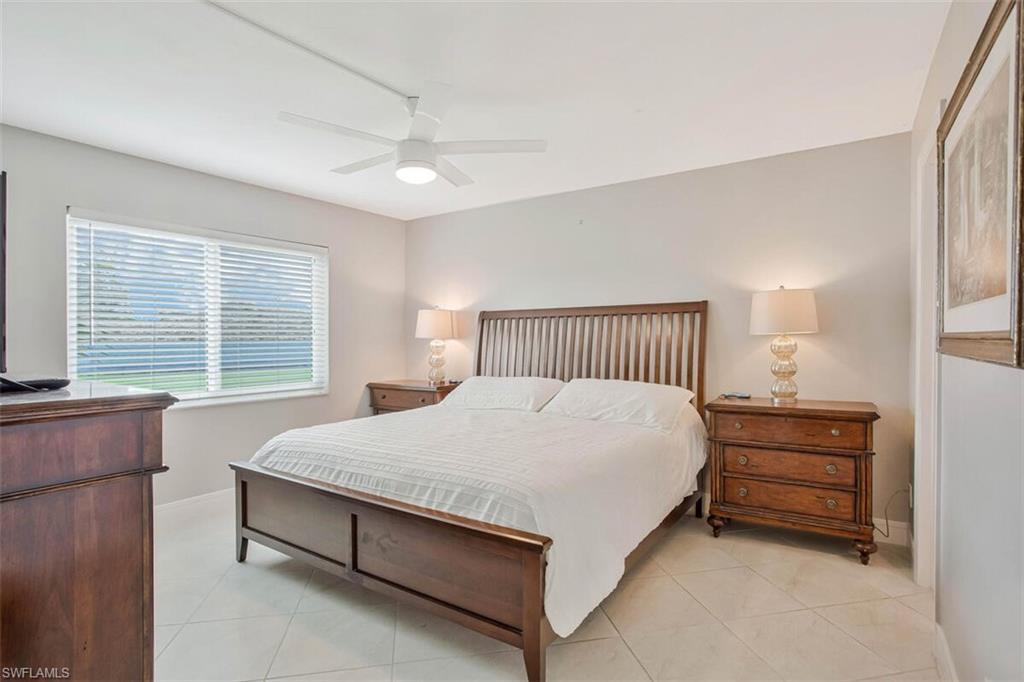 4380 27th Court Southwest, Unit 1 Naples, FL 34116 - Photo 18 of 34 Bedroom with light tile patterned floors and ceiling fan