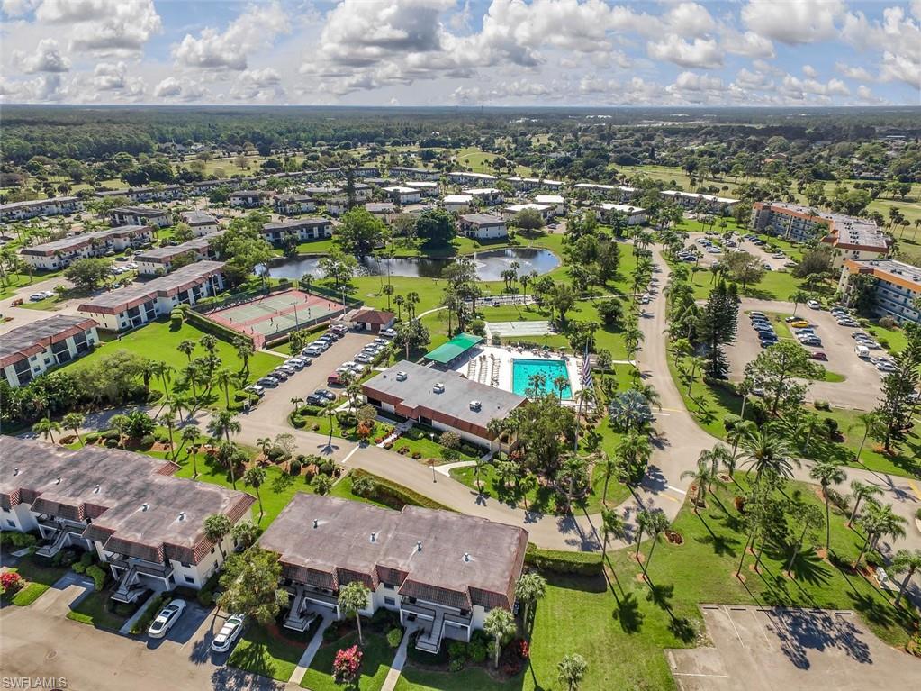 4380 27th Court Southwest, Unit 1 Naples, FL 34116 - Photo 29 of 34 Aerial view of property's location featuring a large heated pool and a catch and release lake with fountain