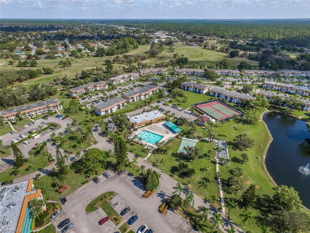 4380 27th Court Southwest, Unit 1 Naples, FL 34116 - Photo 30 of 34 Aerial view of property and surrounding area featuring a large body of water and a golf course