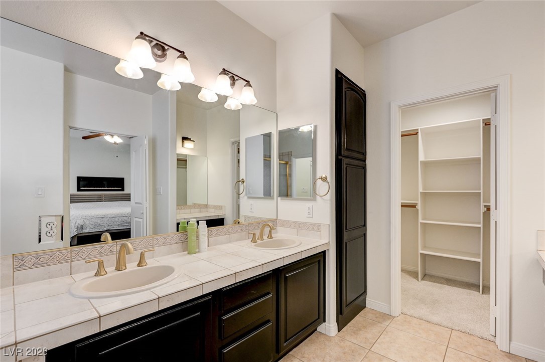 2955 El Camino Road Las Vegas, NV 89146 - Photo 55 of 99 Bathroom with double vanity, ensuite bathroom, a ceiling fan, light tile patterned floors, and a spacious closet