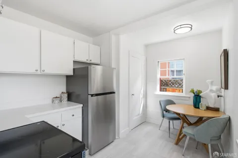 a kitchen with a refrigerator a stove a sink and a dining table with garden view