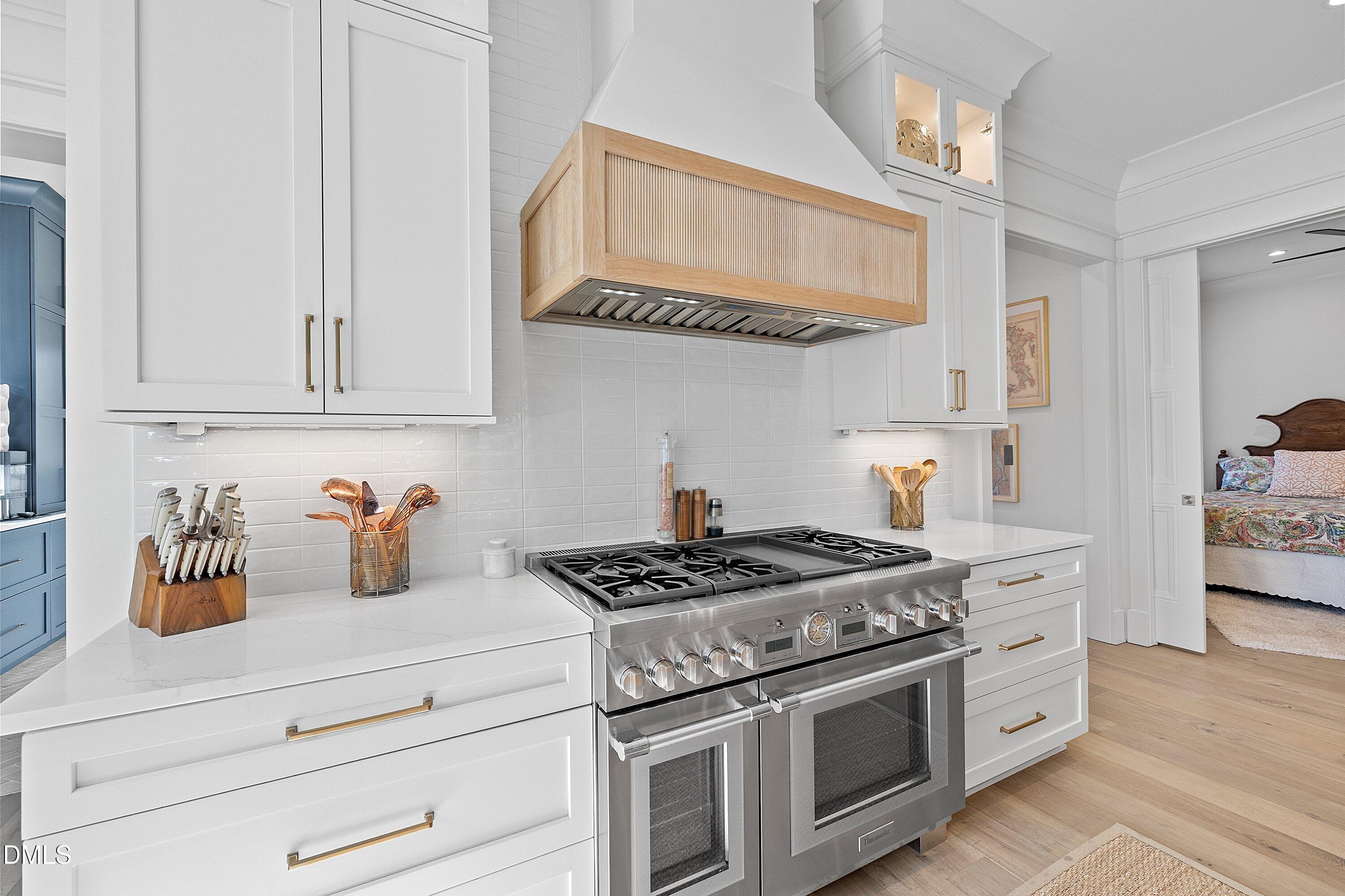 906 Brooks Avenue Raleigh, NC 27607 - Photo 16 of 64 a kitchen with stainless steel appliances granite countertop white cabinets and a stove top oven