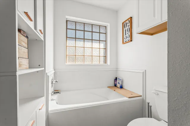 a white bath tub sitting next to a white toilet