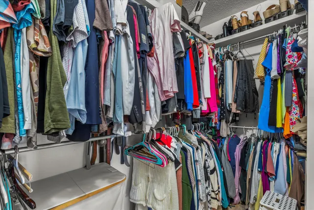 a view of walk in closet with clothes