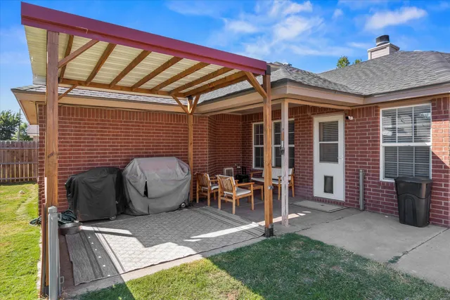 a view of a patio with table and chairs and potted plants