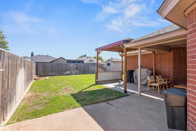a view of a backyard with table and chairs and iron fence