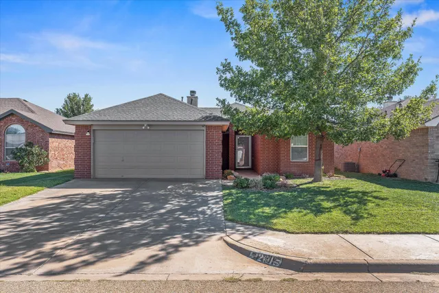 a front view of a house with a yard and a garage