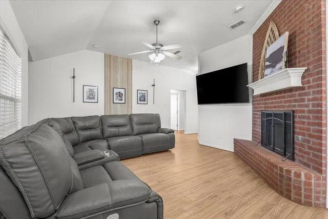 a living room with furniture a flat screen tv and a fireplace