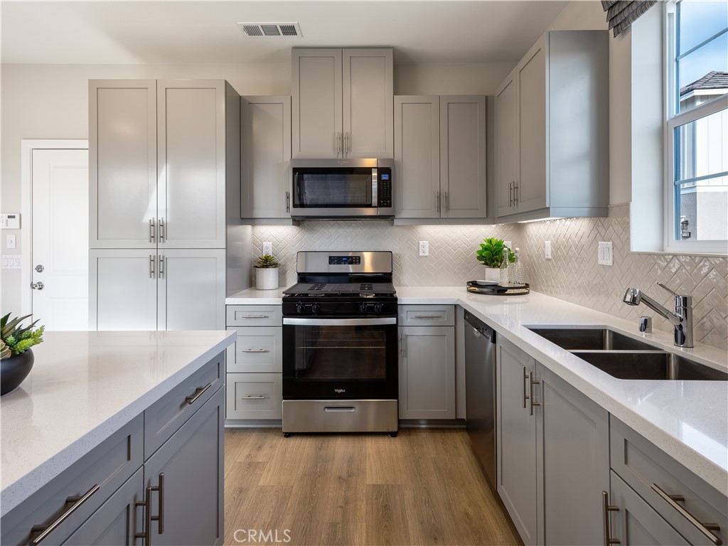 a kitchen with a sink cabinets and stainless steel appliances