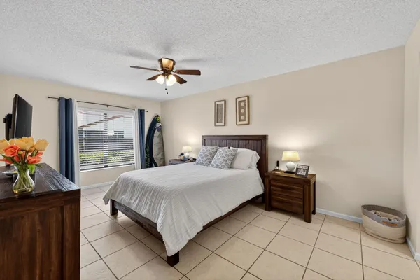 a bedroom with a bed and a flat tv screen on dresser