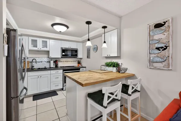 a kitchen with granite countertop white cabinets and stainless steel appliances