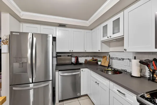 a kitchen with stainless steel appliances a refrigerator a sink and cabinets