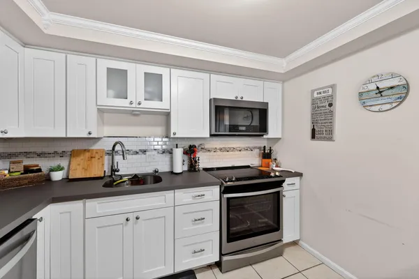 a kitchen with white cabinets and black appliances