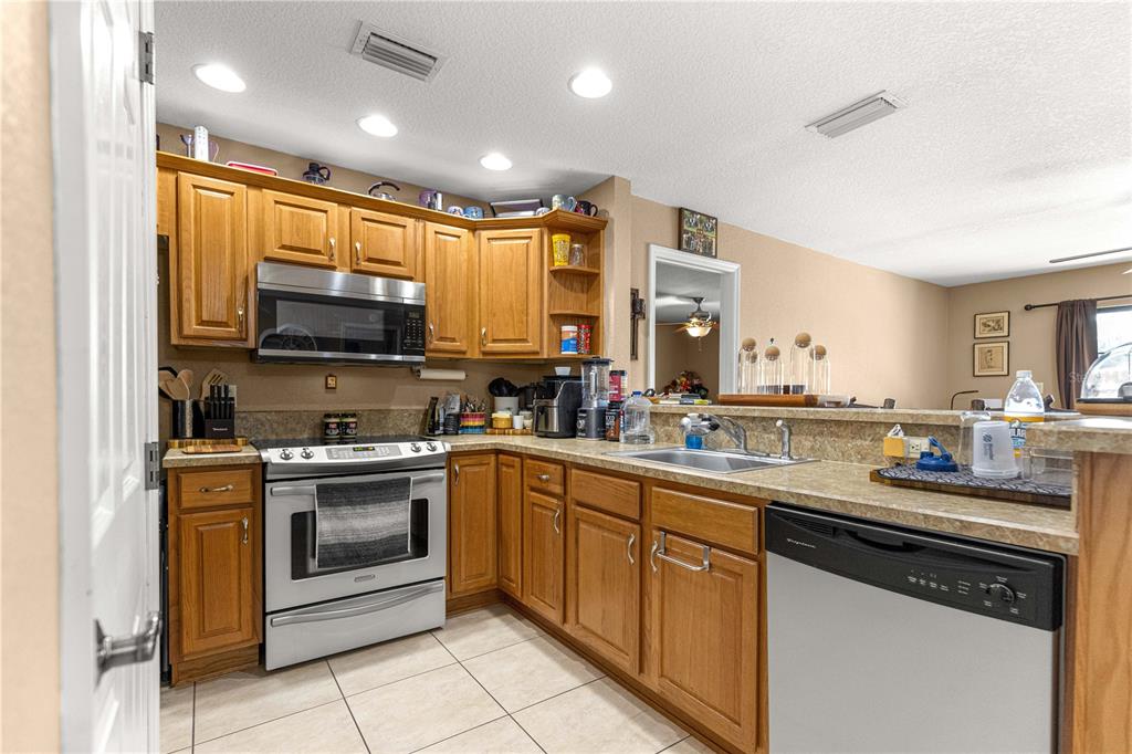 2837 Northeast 3rd Street, Unit 203 Ocala, FL 34470 - Photo 12 of 41 a kitchen with stainless steel appliances a stove sink microwave and cabinets