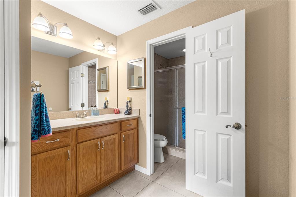 2837 Northeast 3rd Street, Unit 203 Ocala, FL 34470 - Photo 28 of 41 a bathroom with a double vanity sink toilet and shower