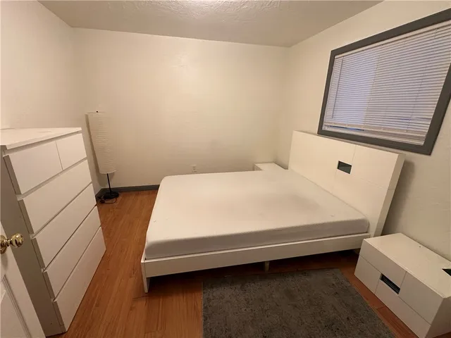 a bed sitting in a bedroom next to a small window