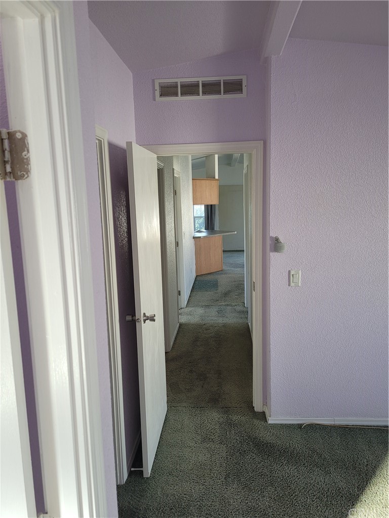 32 Walnut Via Anaheim, CA 92801 - Photo 14 of 24 an empty room with wooden floor and a hallway