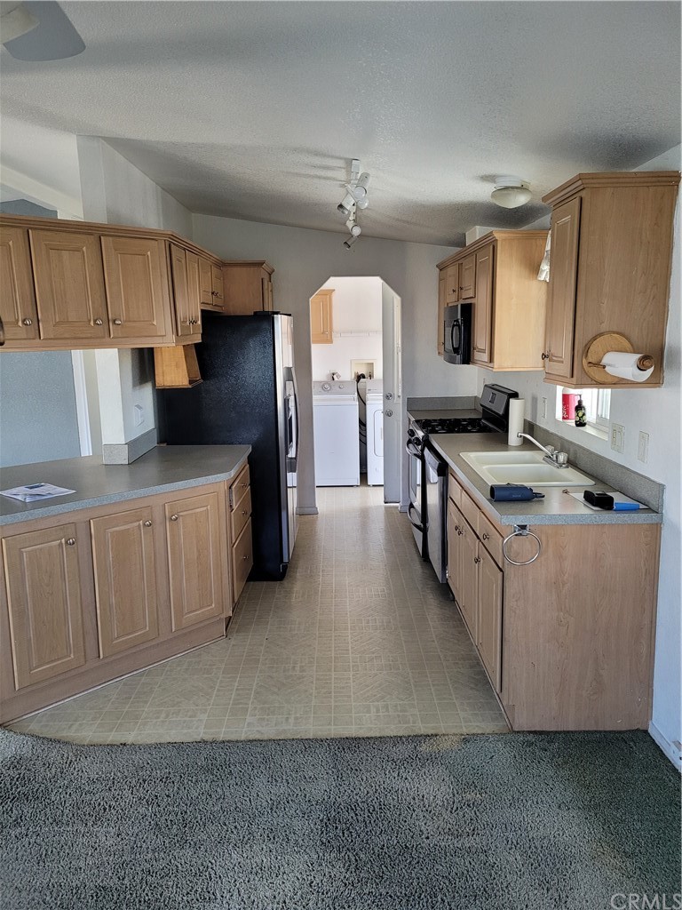 32 Walnut Via Anaheim, CA 92801 - Photo 6 of 24 a kitchen with stainless steel appliances a sink a stove a refrigerator cabinets and a window