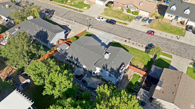 11875 South Elm Ridge Road Sandy, UT 84094 - Photo 40 of 53 Aerial perspective showcasing a residential property with a dark shingled roof, light-colored siding, and a spacious backyard featuring mature trees