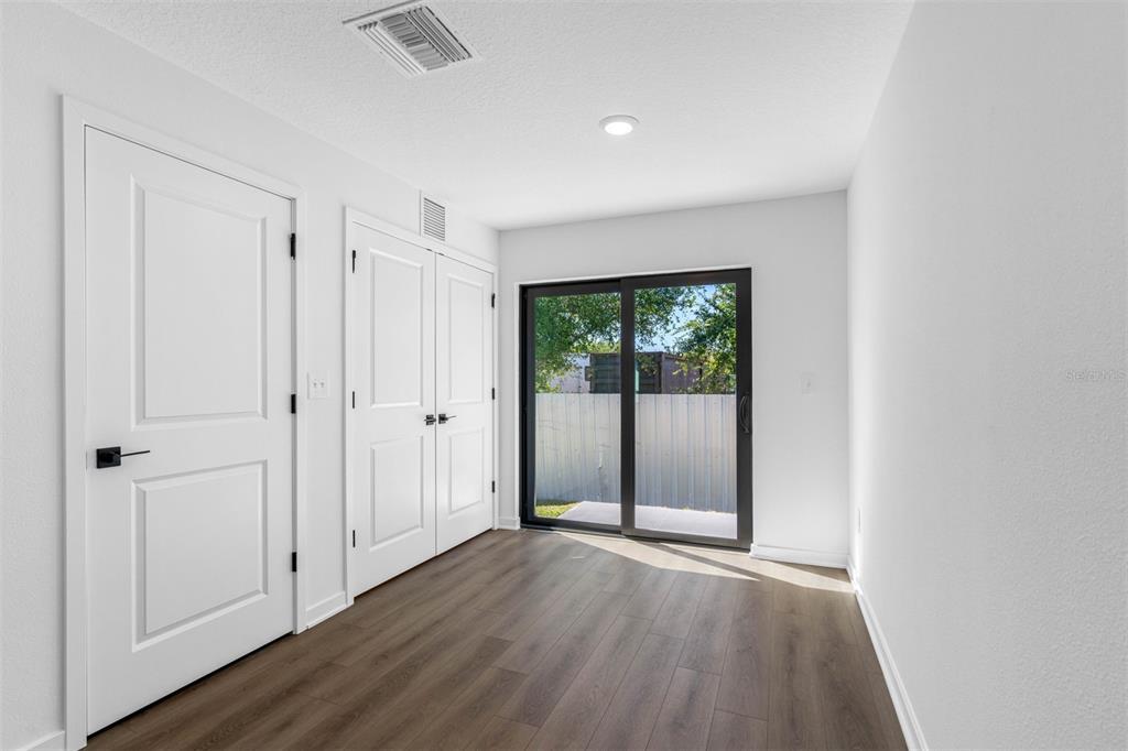 229 Galaxy Avenue Spring Hill, FL 34606 - Photo 5 of 9 an empty room with wooden floor and windows