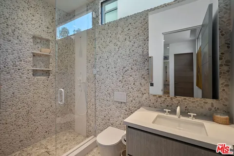 a bathroom with a sink a toilet and shower