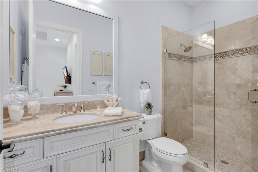 2306 Tradition Way, Unit 102 Naples, FL 34105 - Photo 14 of 39 Guest bathroom with spacious vanity and frameless walk-in shower.