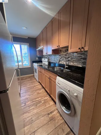 a kitchen with a sink a stove and cabinets