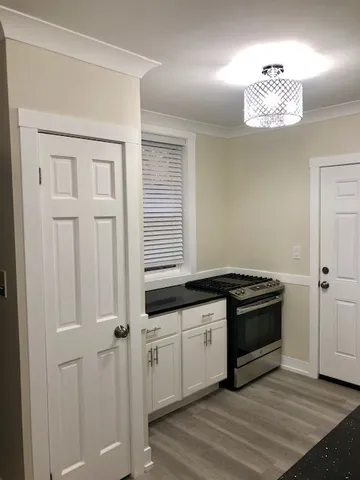 a kitchen with granite countertop a stove a sink and a microwave