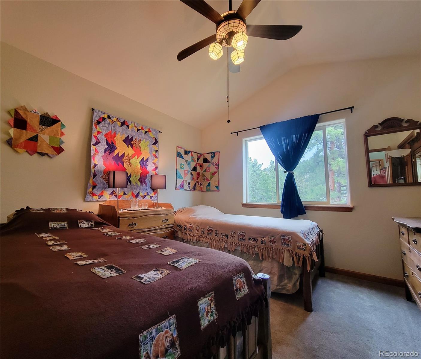 33348 Persistence Avenue Pine, CO 80470 - Photo 16 of 40 a bedroom with a bed a wall painting and a chandelier