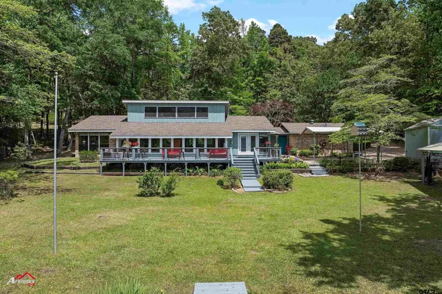 a aerial view of a house with swimming pool next to a big yard