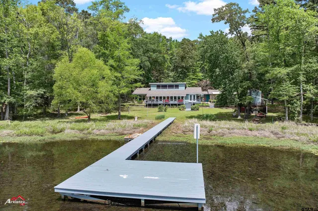 a view of swimming pool with lawn chairs and plants