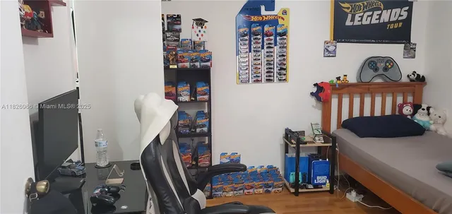 a view of a bedroom with workspace and toys