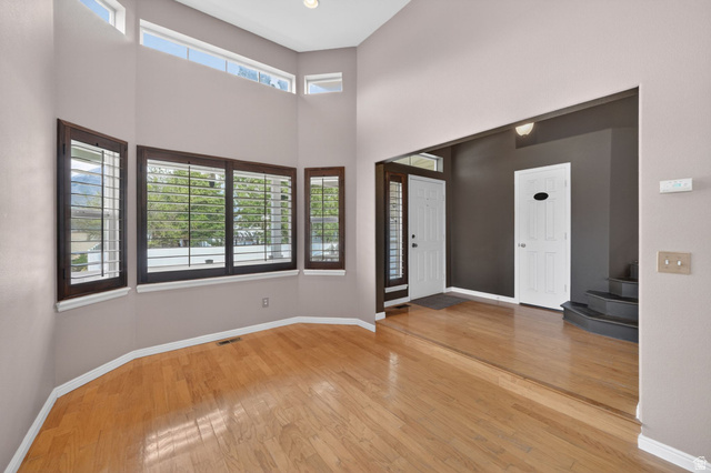 1464 990 West Provo, UT 84601 - Photo 4 of 41 Hardwood-style flooring throughout a sunlit room featuring multiple windows with dark wood frames and white plantation shutters