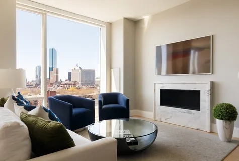a living room with furniture a fireplace and a flat screen tv