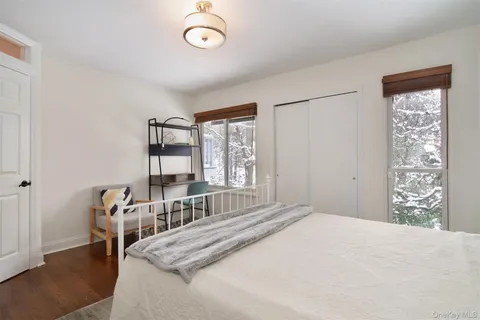 a bedroom with a bed next to a large window