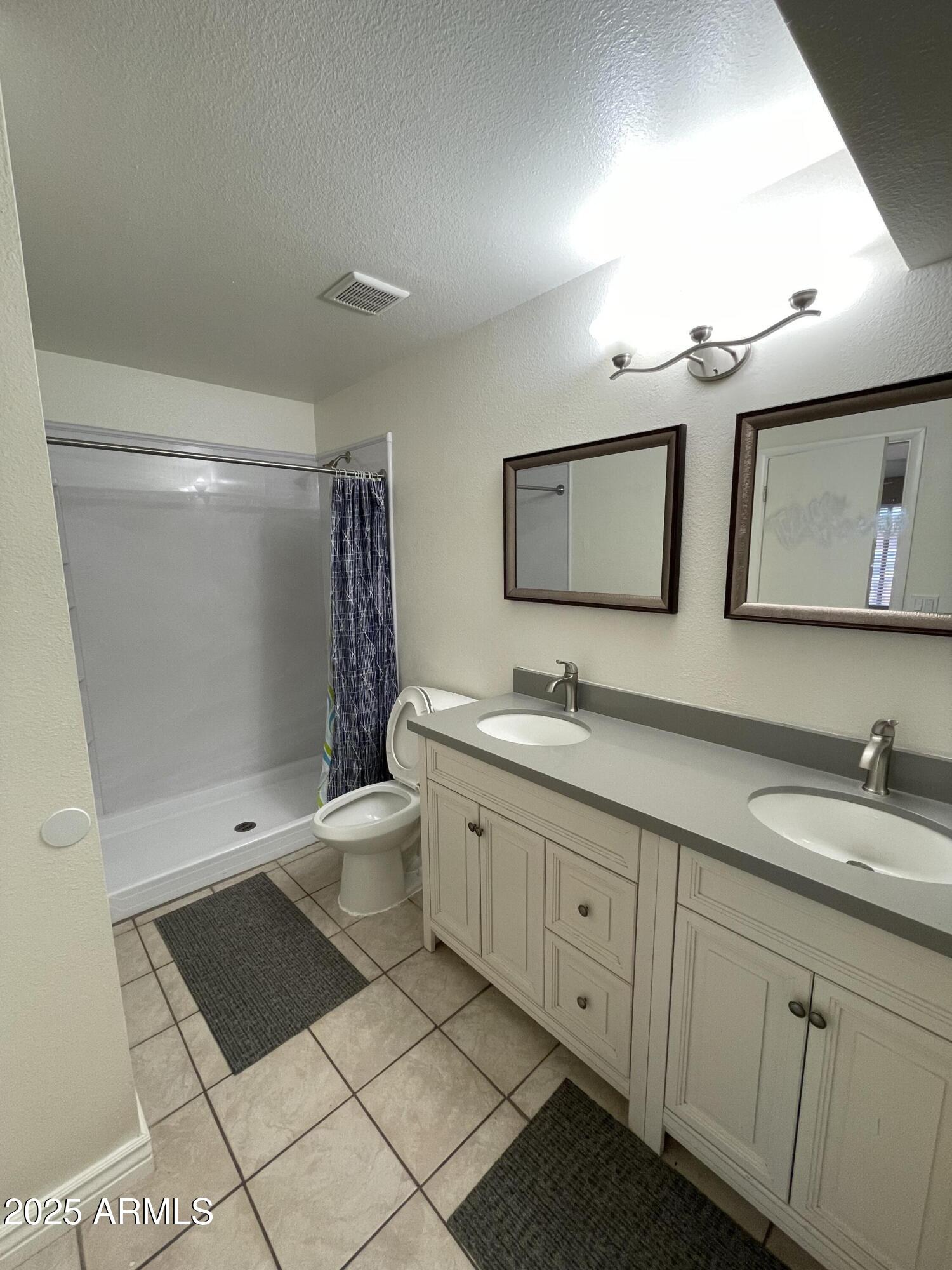 732 West Rice Drive Tempe, AZ 85283 - Photo 14 of 18 a spacious bathroom with a double vanity sink a toilet a mirror and