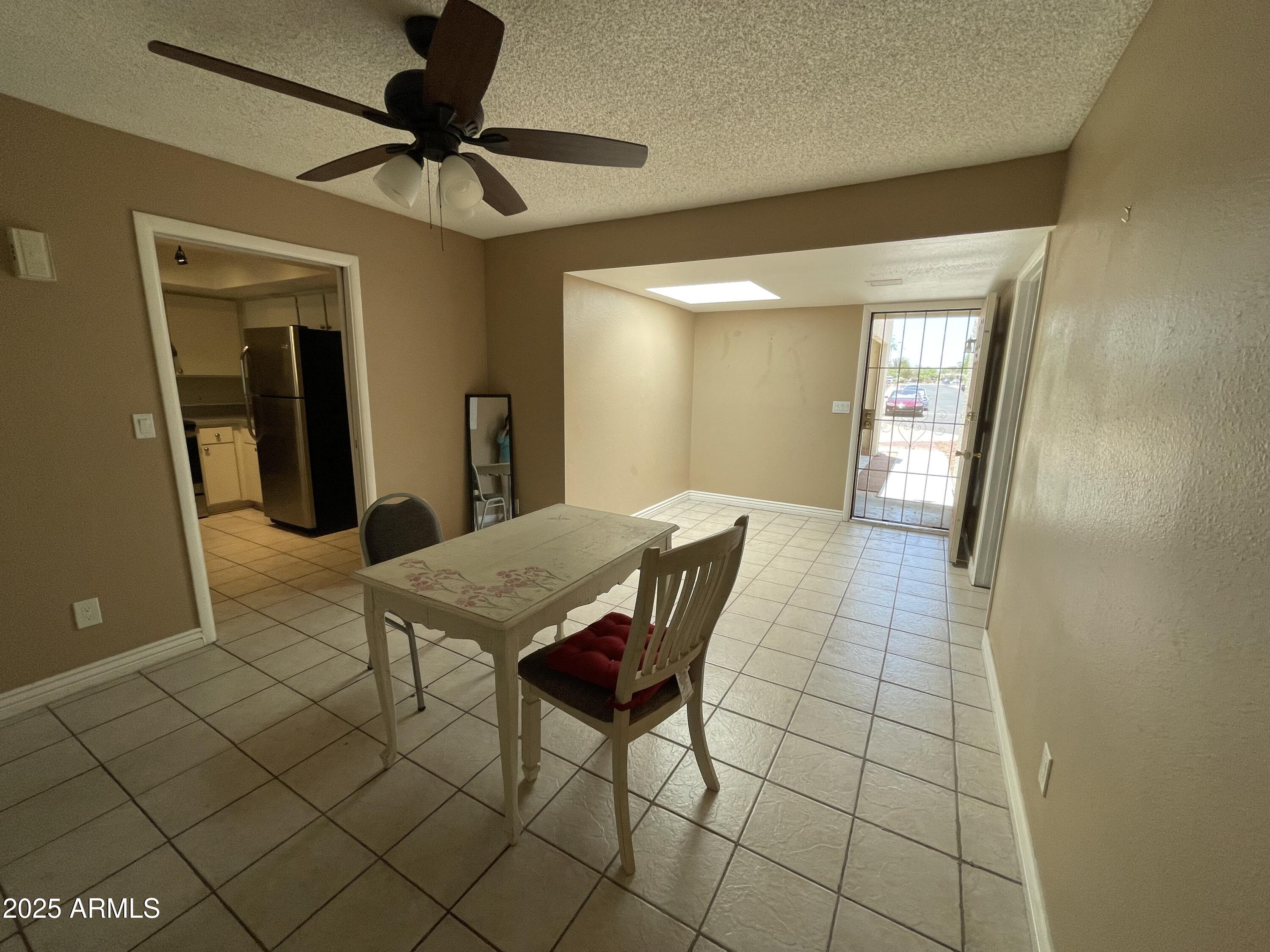 732 West Rice Drive Tempe, AZ 85283 - Photo 6 of 18 a living room with a table chairs and a refrigerator
