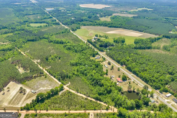 an aerial view of residential houses with outdoor space and trees