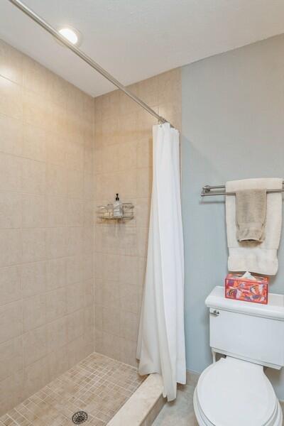 1230 South Drive Way, Unit A Delray Beach, FL 33445 - Photo 22 of 26 a white toilet sitting next to a shower curtain