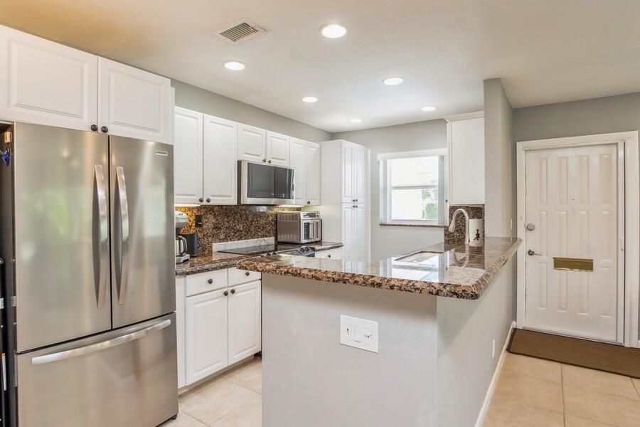 1230 South Drive Way, Unit A Delray Beach, FL 33445 - Photo 6 of 26 a kitchen with a refrigerator a sink and cabinets