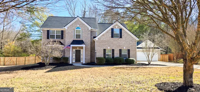 a front view of a house with a yard covered in snow