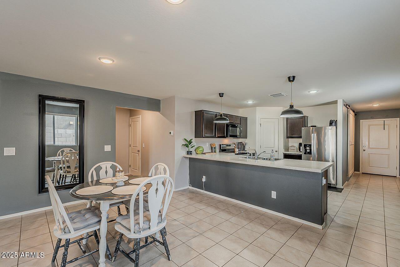 8721 South 253rd Drive Buckeye, AZ 85326 - Photo 12 of 44 a kitchen with stainless steel appliances kitchen island granite countertop a sink and cabinets