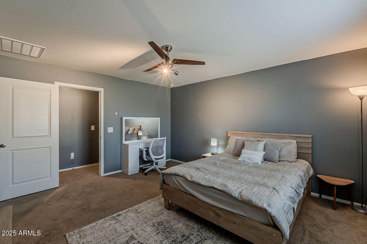 8721 South 253rd Drive Buckeye, AZ 85326 - Photo 22 of 44 a bedroom with a bed and a ceiling fan