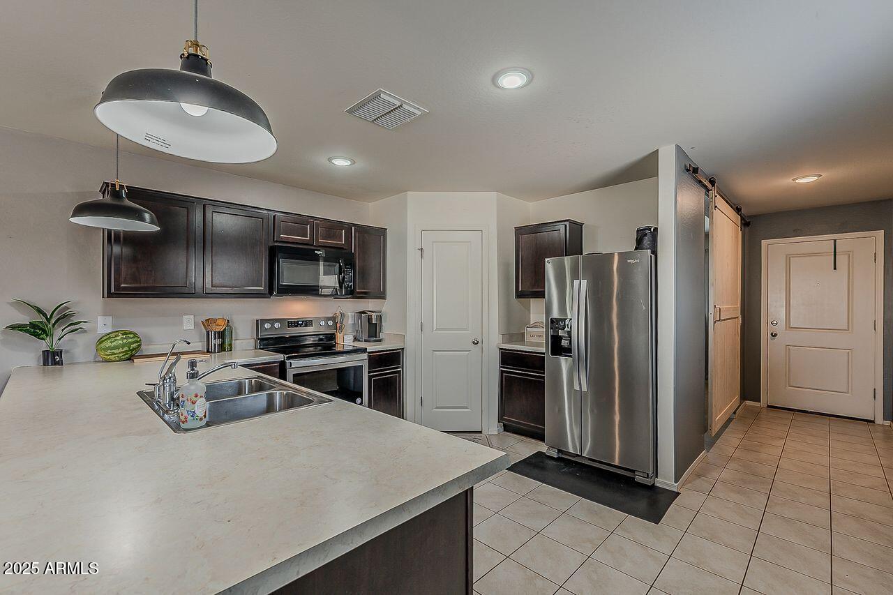 8721 South 253rd Drive Buckeye, AZ 85326 - Photo 7 of 44 a kitchen with sink cabinets and stainless steel appliances