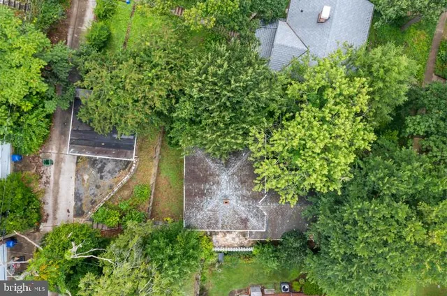 an aerial view of residential house with outdoor space and trees all around
