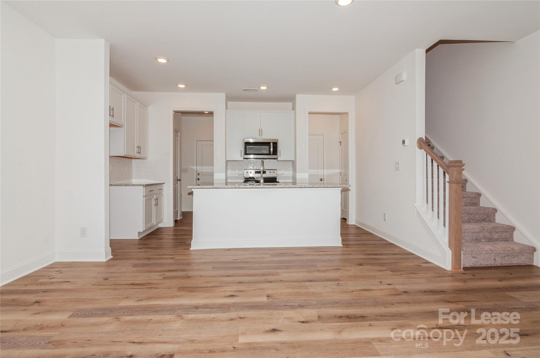 6006 Cedar Chip Way Matthews, NC 28105 - Photo 12 of 35 a view of kitchen with kitchen island a sink wooden floor and a refrigerator