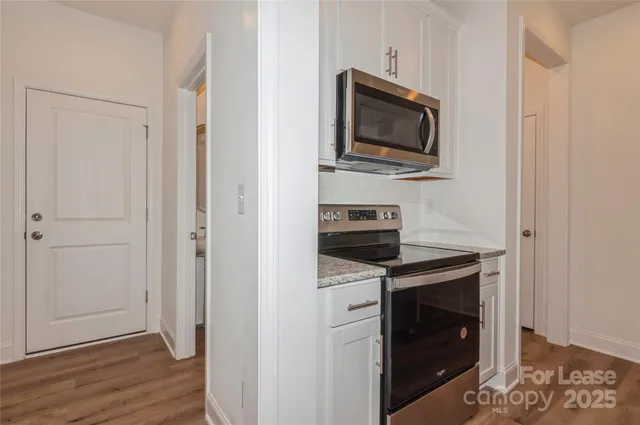 a kitchen with stainless steel appliances granite countertop a sink a stove and a refrigerator