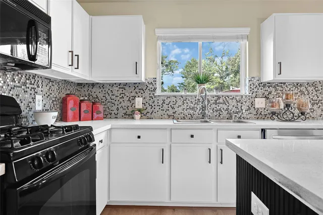 a kitchen with stainless steel appliances white cabinets and a stove top oven